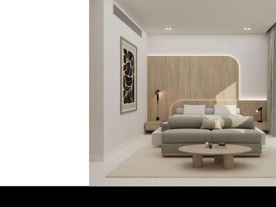 Modernes Hotelzimmer mit Bett, Sessel, Kunst an der Wand und viel natürlichem Licht.