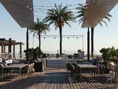 Offener Lounge-Bereich am Meer mit Tischen, Stühlen und Palmen unter Sonnensegeln.