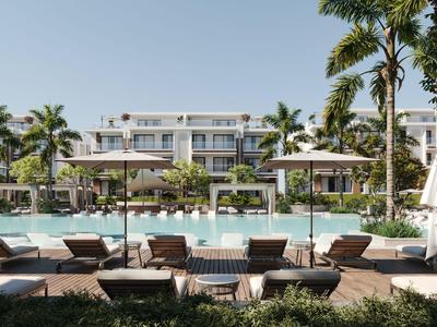 Luxuriöses Resort mit Pool, Sonnenliegen und Palmen unter klarem Himmel.