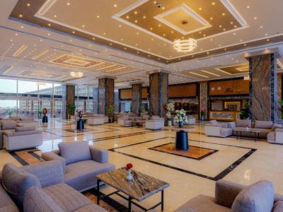 Geräumige Hotellobby mit modernen Sofas, großem Blumenarrangement und stilvoller Beleuchtung.