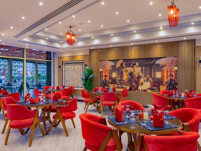 Moderner Hotelrestaurant mit roten Stühlen und dekorativer Wandgestaltung.