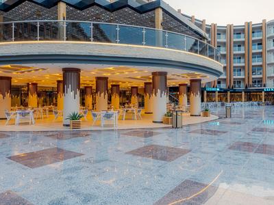 Großes Hotel mit rundem, überdachtem Sitzbereich und Marmorboden auf der Terrasse.