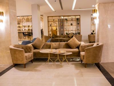 Gemütliche Sitzecke mit braunen Sesseln und Couch in einem eleganten Hotellobbybereich.