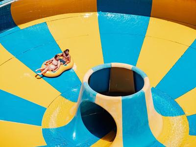 Twee mensen glijden op een kleurrijke waterglijbaanring in een waterpark.