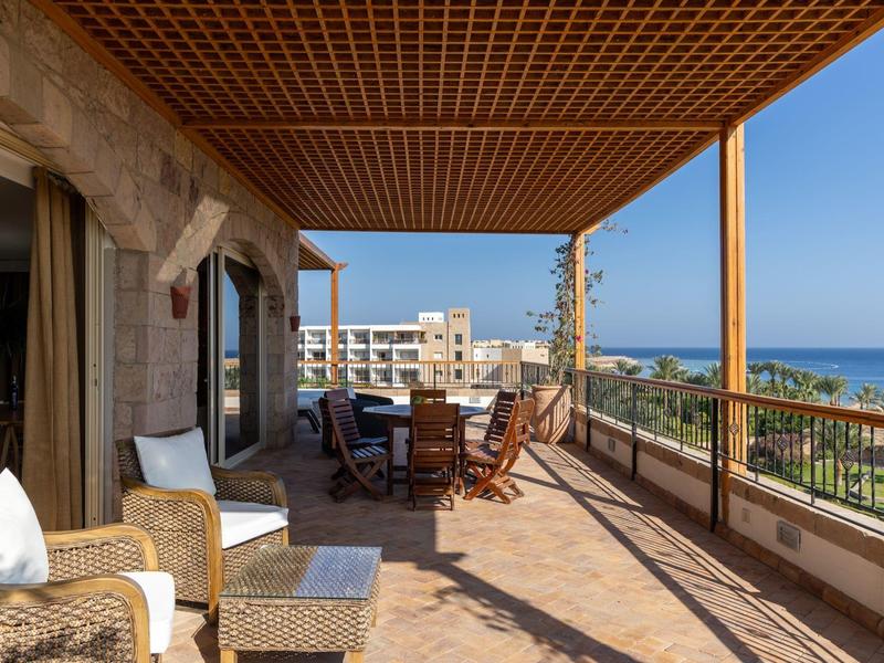 Przestronny taras z miejscami do siedzenia i widokiem na morze przy bezchmurnym niebie.