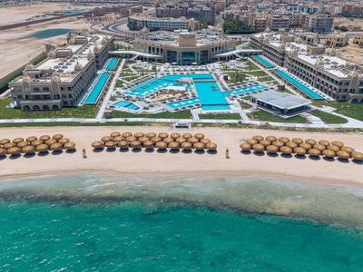 Luxury resort with a large pool and direct access to a sandy beach and turquoise sea.