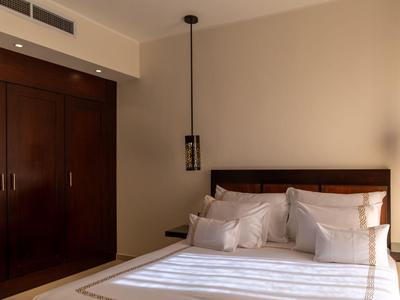 Modern bedroom with double bed, large wooden wardrobes, and ceiling pendant lights