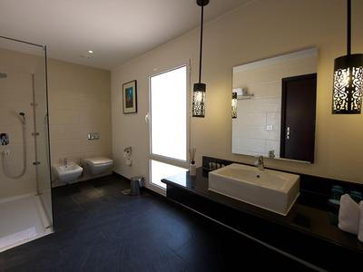 Modern bathroom with shower, sink, bidet, and toilet in a hotel room.