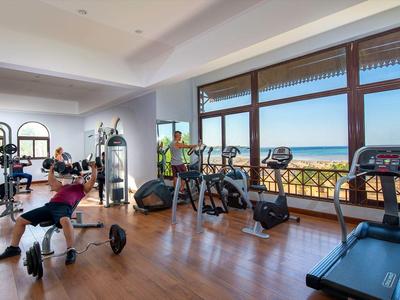 Fitness centrum s moderním vybavením a velkými okny s výhledem na město a moře.