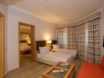 Gezellige hotelkamer met bed, bank, tv en eigen badkamer met warm licht.