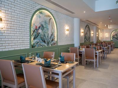 Restaurante moderno con mesas de madera, sillas cómodas y decoración natural en un entorno luminoso.