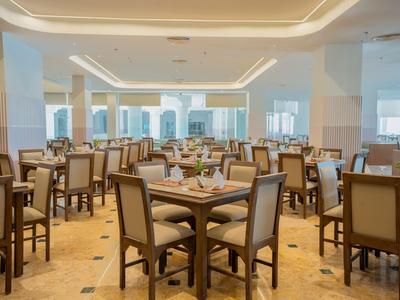 Comedor luminoso y espacioso con muchas mesas y sillas cómodas en un hotel.