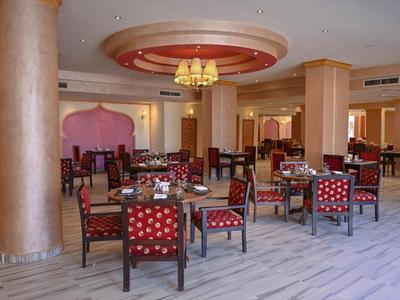 Geräumiger Hotelrestaurant mit rot gepolsterten Stühlen und hellen Marmorböden.