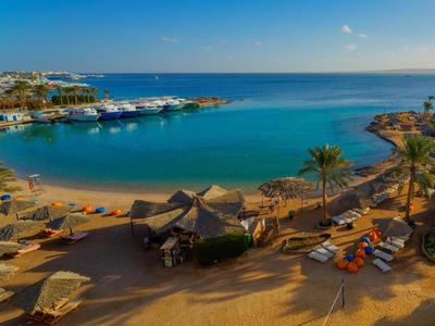 Plážové letovisko s slunečníky a lehátky u klidné zátoky