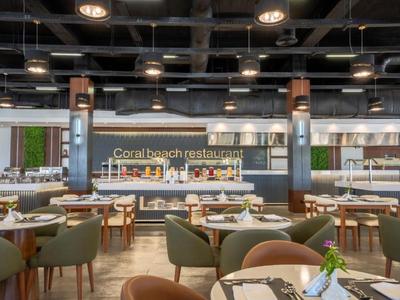 Elegantní hotelová restaurace s kulatými stoly, pohodlnými židlemi a moderní, útulnou atmosférou.