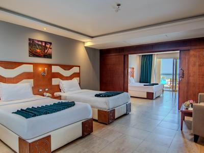 Modern hotel room with two single beds and balcony access.