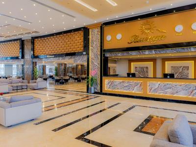 Spacious hotel lobby with a modern reception desk and comfortable seating areas.