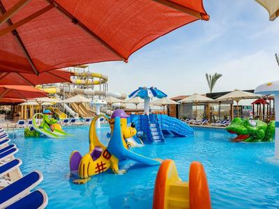 Colorful outdoor pool with water slides, umbrellas, and lounge chairs, perfect for family vacation.