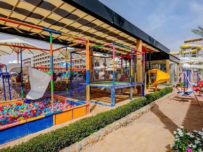 Outdoor area of a hotel playground with colorful slides, climbing frames, and a ball pit.