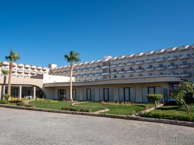 Moderner Hotelkomplex mit mehrstöckigen Gebäuden, gepflegtem Garten und klarem, blauem Himmel.