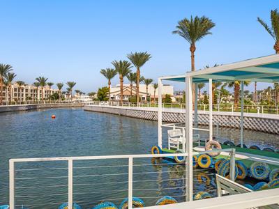 Hotel complex with pool and palm trees under blue sky