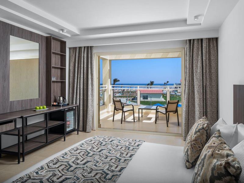 Camera d'hotel moderna con vista sulla terrazza e cielo azzurro.