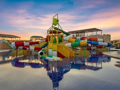 Scivoli d'acqua colorati e strutture da gioco in una piscina al tramonto