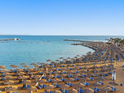 Spiaggia con ombrelloni e lettini gialli, vista sul mare calmo.