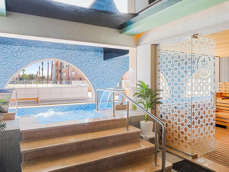 Spa con piscina interna, scale e sauna in un ambiente luminoso e moderno.