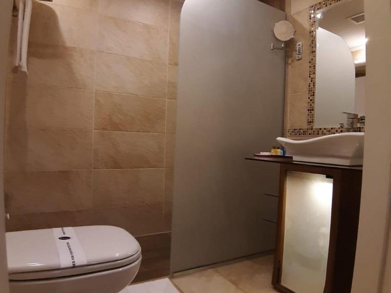 Bagno moderno con WC, doccia con porta in vetro satinato e lavabo.