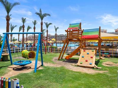 Colorful playground with climbing frame, swing, and slide in sunny garden area.