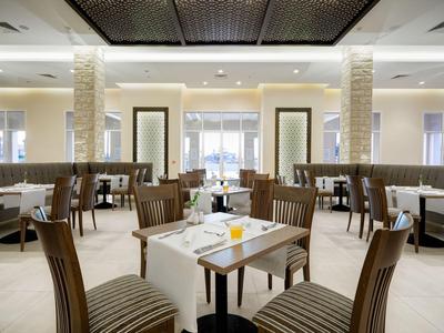 Elegantes, modernes Hotelrestaurant mit gedeckten Tischen und bequemen Stühlen.