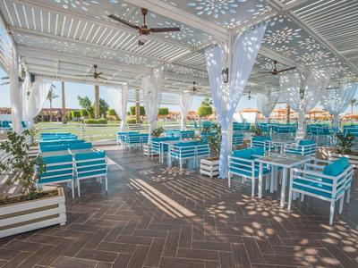 Offener Lounge-Bereich mit blauen Sitzmöbeln unter einem weißen überdachten Pavillon.