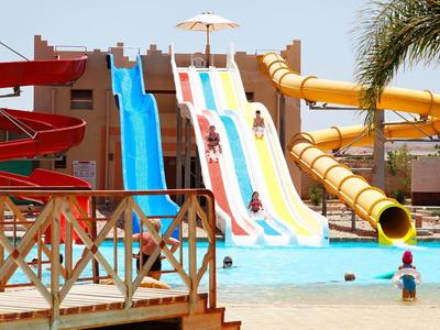 Wasserpark mit bunten Rutschen, blauem Pool und Menschen, die Spaß haben.