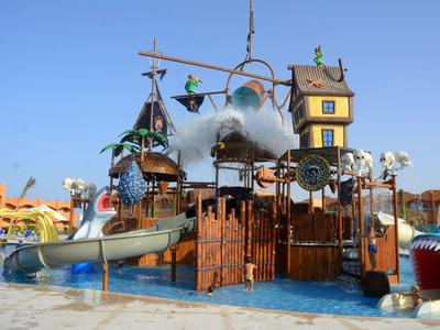 Colorful water playground with slides, towers, and water features under a clear blue sky.