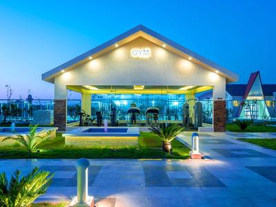 Restaurant d'hôtel moderne avec entrée couverte et jardin illuminé au crépuscule
