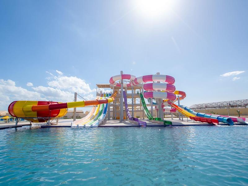 Complesso di scivoli d'acqua colorati su una piscina al sole.