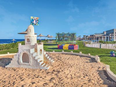 Castello di sabbia in un parco giochi esterno vicino a un hotel sul mare.