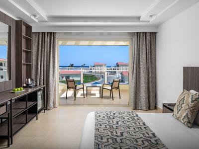 Modern hotelkamer met terras, zeezicht en gezellige buitenzitplek.