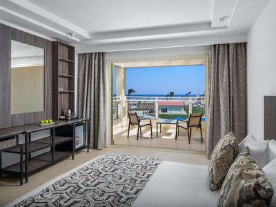 Modern hotelkamer met uitzicht op het terras en de blauwe lucht.