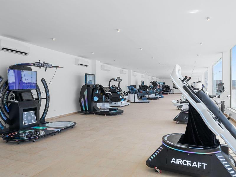 Lichte fitnessruimte met moderne trainingsapparatuur en grote ramen.