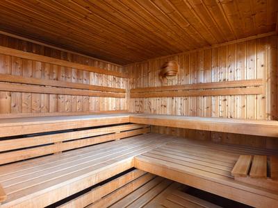 Helle Holza sauna mit mehrstufigen Sitzbänken und Holzwänden und Decke.