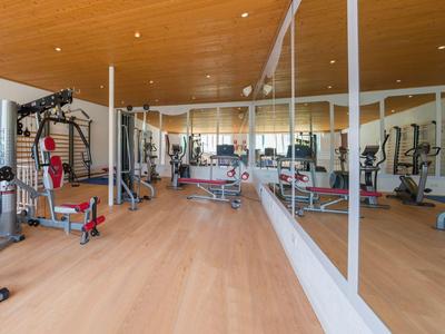 Gimnasio moderno con suelo de madera y grandes espejos en la pared