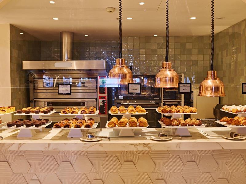 Bufet s různými čerstvými pečivy v moderně navržené hotelové kuchyni.