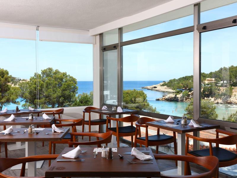 Salle à manger lumineuse avec grandes fenêtres et vue sur la mer