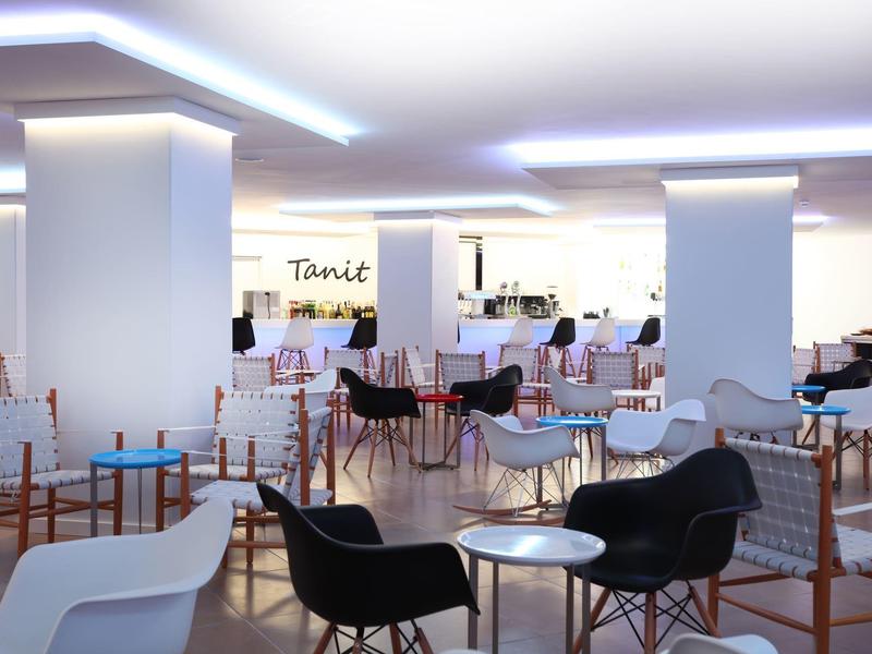 Espace lounge d'hôtel bien éclairé avec divers sièges et tables.