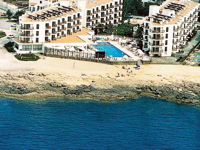 Kompleks hotelowy z basenem tuż przy morzu i piaszczystej plaży w słonecznej lokalizacji.