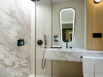 Bagno moderno con doccia in vetro e lavabo in marmo.