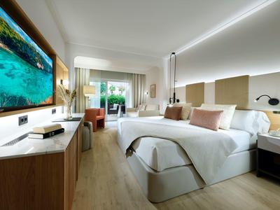 Camera d'hotel moderna con letto matrimoniale e vista sulla natura dalla finestra.