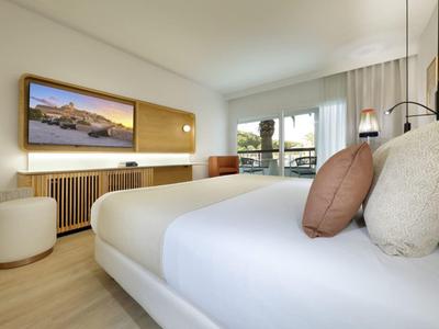 Camera d'hotel moderna con letto confortevole, ampie finestre e arredamento minimalista.